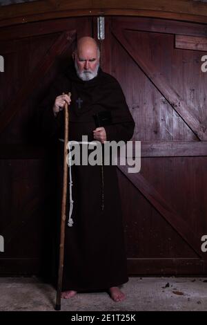 Moine franciscain, appâté, avec sa bible et son personnel. Banque D'Images