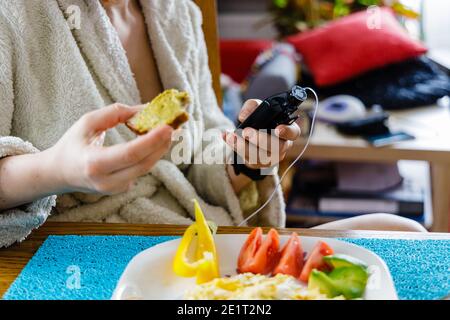 Traitement moderne du diabète, femme vérifiant le niveau de glucose et doser l'insuline avec pompe à insuline avant son petit déjeuner sain Banque D'Images