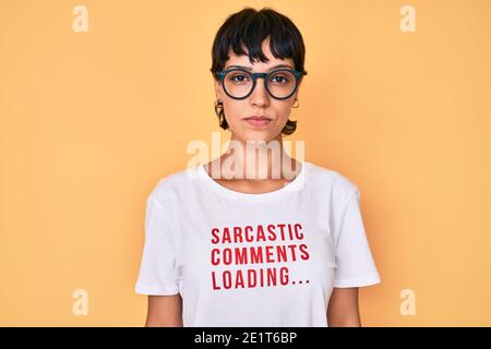Belle femme brunettte portant des commentaires sarcastique chargement du t-shirt avec une expression sérieuse sur le visage. Simple et naturel regarder la caméra. Banque D'Images