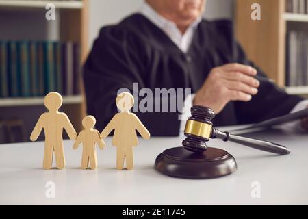 Un gavel sur le bloc son et des figurines de petit membre de la famille sur table du juge dans la salle d'audience Banque D'Images