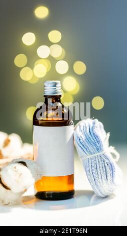 Ensemble de produits de fête pour le visage. Toner en bouteille de verre et pile de tampons ronds de coton réutilisables. Maquette d'étiquette blanche. Bokeh lumières effet de flou étincelant fect b Banque D'Images