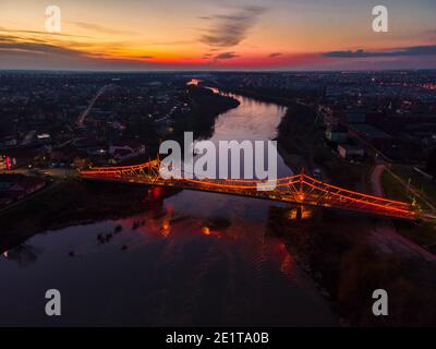 Photographie aérienne d'un pont lumineux sur l'eau au coucher du soleil Banque D'Images