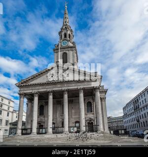 Un homme sans abri et son chien s'assoit sur les marches de St. Martin-in-the-Fields à Londres pendant le confinement. Banque D'Images