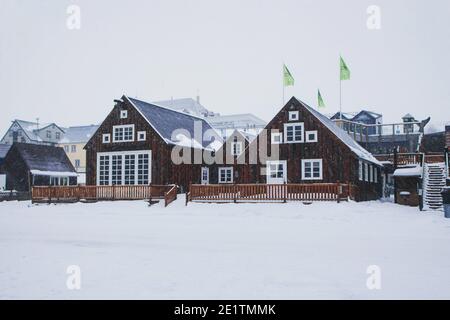 L'hiver magnifique vue sur la neige typique maison traditionnelle en bois bâtiment front de mer À Husavik, nord de l'Islande, en Europe Banque D'Images