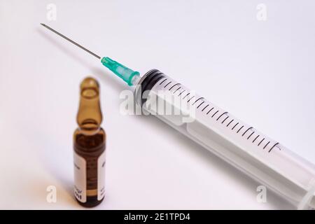 Aiguille de seringue et flacon de médicament sur fond blanc Banque D'Images