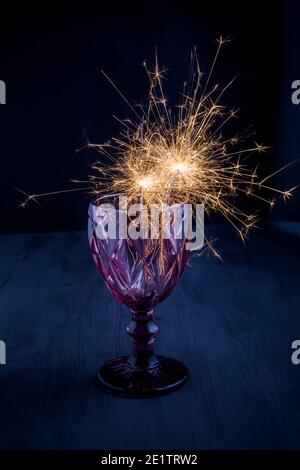 Sparkler en verre à vin sur fond sombre Banque D'Images