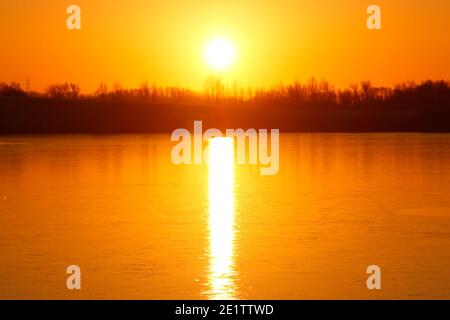 Lever de soleil au-dessus d'un lac Bowers gelé à St Aidan's nature Parc à Swillington, Leeds, West Yorkshire Banque D'Images