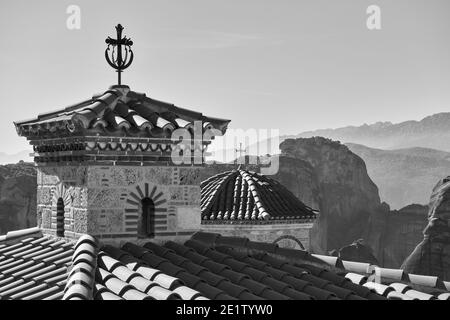 Dômes avec des croix de Varlaam monastère orthodoxe et des roches de Meteora en arrière-plan, la Grèce. Paysage grec noir et blanc Banque D'Images