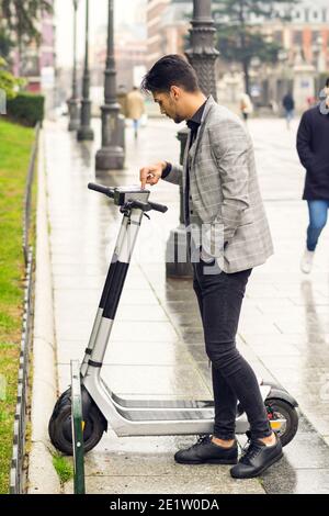 jeune homme louant un scooter électrique Banque D'Images