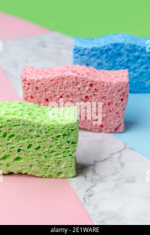 Disposition créative avec éponges pour le lavage de la vaisselle sur fond multicolore Banque D'Images