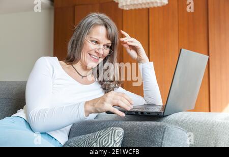 Grand-mère est heureuse de son nouvel ordinateur comme elle utilise pour communiquer avec ses neveux Banque D'Images