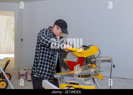 Construction à la maison découpe des moulures en bois avec scie circulaire Banque D'Images