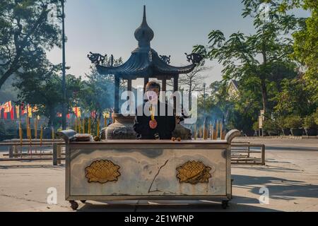 Une personne prie devant le monastère de po Lin dans le village de Ngong Ping sur l'île de Lantau, à Hong Kong Banque D'Images