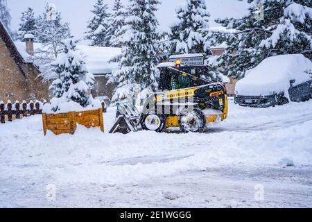 Auron, France 01.01.2021 Chargeuse sur pneus déneigement sur une station de ski. Déblayer la route de la neige. Photo de haute qualité Banque D'Images