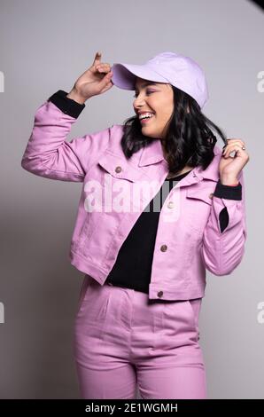 Portrait d'une belle femme souriante vêtue de rose et de rose cap regardant son côté droit Banque D'Images