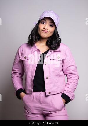 Portrait de femme en costume rose avec casquette avec confusion Expression Banque D'Images