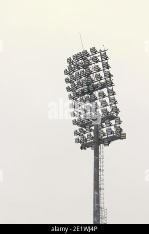 Projecteur de stade avec poteau métallique, mât d'éclairage, tour avec projecteurs dans le stade de sport contre le ciel blanc Banque D'Images