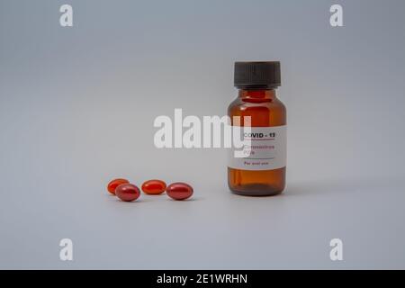 Petite bouteille de pilule / flacon (flacon) avec une étiquette qui Lit 'Covid - 19 comprimés de virus Corona pour usage oral Isolé sur fond blanc médecine pour prévenir Banque D'Images