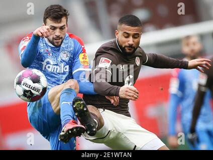 Hambourg, Allemagne. 09e janvier 2021. Football: 2ème Bundesliga, Matchday 15, FC St. Pauli - Holstein Kiel au stade Millerntor. Daniel-Kofi Kyereh de St.Pauli et Jonas Meffert de Kiel (l) dans un duel pour le ballon. Crédit : Christian Charisius/dpa - NOTE IMPORTANTE : Conformément aux règlements de la DFL Deutsche Fußball Liga et/ou de la DFB Deutscher Fußball-Bund, il est interdit d'utiliser ou d'avoir utilisé des photos prises dans le stade et/ou du match sous forme de séquences et/ou de séries de photos de type vidéo./dpa/Alay Live News Banque D'Images