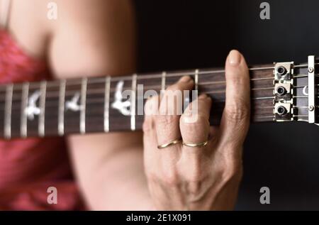 mains de femme jouant de la guitare acoustique, gros plan. Banque D'Images