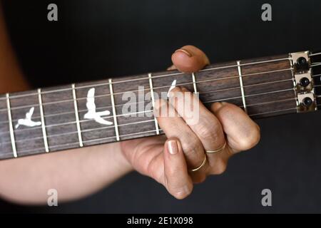 mains de femme jouant de la guitare acoustique, gros plan. Banque D'Images