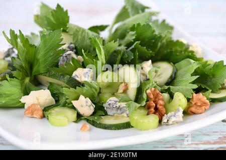 Salade de feuilles de céleri et de tiges avec tranches de concombre frais, fromage bleu, noix écrasées. Banque D'Images