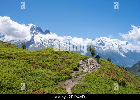 Randonneur sur un sentier de randonnée, Aiguilette des Posettes, en arrière-plan, sur les sommets de montagne Aiguille de Chamois et Aiguille de Praz-Torrent, Chamonix Banque D'Images