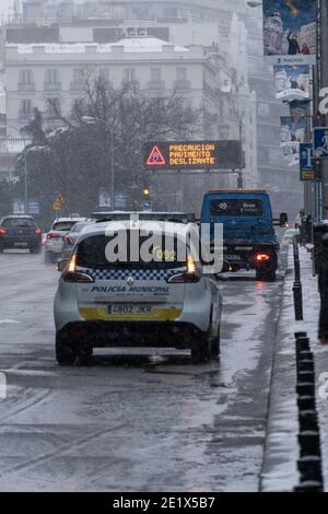 Madrid, Espagne - janvier 2021: Arrêt de voiture de police et de camion de remorquage dans la rue Alcala à Madrid avec le panneau de lith en arrière-plan avec de la neige épaisse due à Filo Banque D'Images