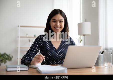 Heureux étudiant asiatique de race mixte étudiant à distance sur les cours en ligne. Banque D'Images