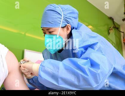Pékin, Chine. 10 janvier 2021. Un travailleur médical inocule un receveur avec un vaccin COVID-19 à l'hôpital universitaire de Pékin, à Beijing, capitale de la Chine, le 10 janvier 2021. Beijing est prévu de terminer l'inoculation pour les groupes clés avant le Festival de printemps, qui se déroule le 12 février de cette année. Crédit: REN Chao/Xinhua/Alay Live News Banque D'Images