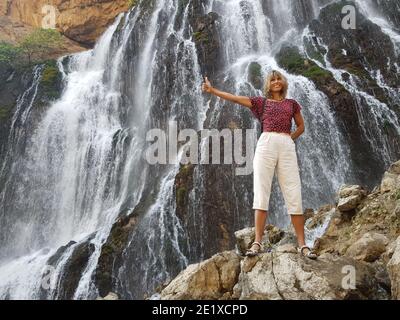 Fille souriante devant la cascade massive de Kapuzbasi. Banque D'Images