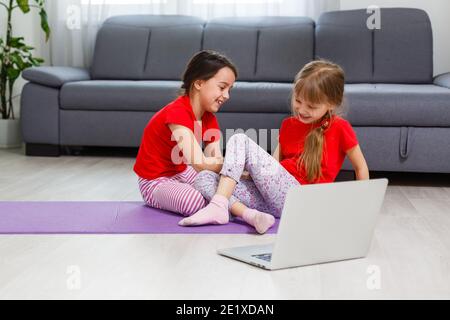 Image pleine longueur petites filles s'amusant à la maison sportive active fille enfant. Activités de loisirs amusantes, concept de style de vie sain et sportif Banque D'Images