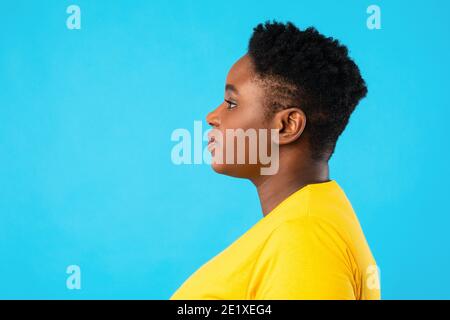 Profil Portrait de la femme afro-américaine en surpoids sur fond bleu Banque D'Images