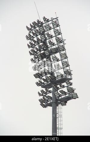 Projecteur de stade avec poteau métallique, mât d'éclairage, tour avec projecteurs dans le stade de sport contre le ciel blanc Banque D'Images