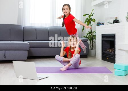 Image pleine longueur petites filles s'amusant à la maison sportive active fille enfant. Activités de loisirs amusantes, concept de style de vie sain et sportif Banque D'Images