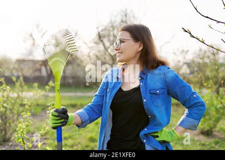 Jardinage de printemps, portrait de femme mûre souriante jardinier avec râteau Banque D'Images