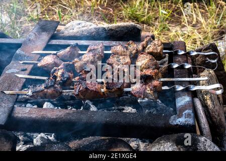 Délicieux barbecue appétissant cuisiné au feu. Dans la nature, de belles coupes appétissantes de viande sont grillées. Gros plan. Mise au point sélective. Banque D'Images