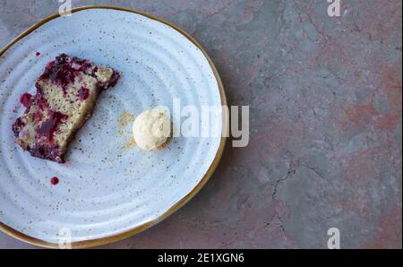 Crumble aux fruits rouges et petit dessert à la crème glacée à la vanille prêt à manger sur une table rose en marbre. Copiez l'espace sur le côté droit. Banque D'Images