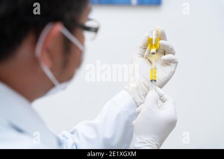Vaccin Covid-19, médecin, infirmière, scientifique, chercheur main dans des gants tenant la grippe, la rougeole, le vaccin coronavirus préparation de la maladie, la médecine et le médicament c Banque D'Images