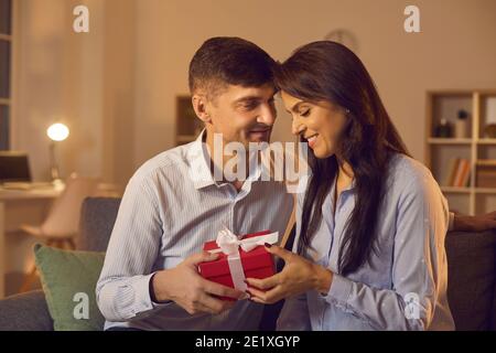 Un jeune homme amoureux félicite sa petite amie pour la Saint-Valentin en lui offrant un cadeau. Banque D'Images