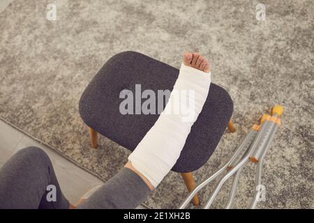 Femme avec une jambe cassée dans le plâtre moulé en cours de réhabilitation et repos à la maison Banque D'Images