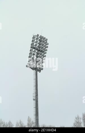 Projecteur de stade avec poteau métallique, mât d'éclairage, tour avec projecteurs dans le stade de sport contre le ciel blanc Banque D'Images