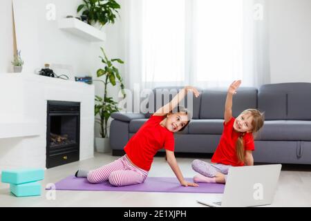 Image pleine longueur petites filles s'amusant à la maison sportive active fille enfant. Activités de loisirs amusantes, concept de style de vie sain et sportif Banque D'Images