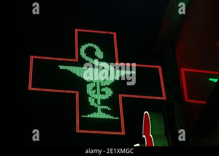 Croix de pixels lumineuse des lampes LED sur fond noir. Coupe Hippocrate, croix avec un contour rouge et un serpent enveloppé autour d'un bol photo de stock avec emp Banque D'Images