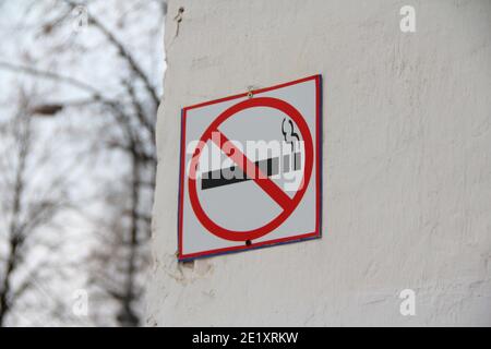 Pas de signe de tabagisme sur le mur blanc, concept de soins de santé, renoncement au tabac. Fumer de la cigarette dans un cercle rouge barré. Photo de stock avec espace vide Banque D'Images