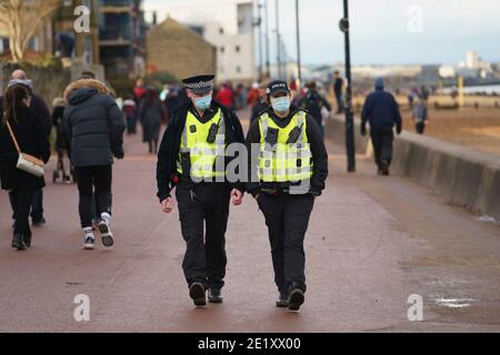 Portobello, Écosse, Royaume-Uni. 10 janvier 2021. En dépit d'un confinement national actuellement imposé en Écosse, la promenade et la plage de Portobello étaient occupées par un grand nombre de personnes qui y passaient dimanche après-midi. Plusieurs patrouilles de police étaient évidentes, la plupart du temps en gardant la clé basse, mais les agents ont parlé aux propriétaires de cafés pour les inciter à garder une distance sociale correcte entre les clients. Iain Masterton/Alay Live News Banque D'Images