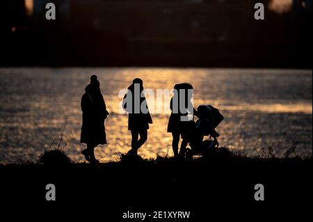 Hambourg, Allemagne. 10 janvier 2021. Une famille est à la jetée de Teufelsbrück par temps ensoleillé. Credit: Daniel Reinhardt/dpa/Alay Live News Banque D'Images