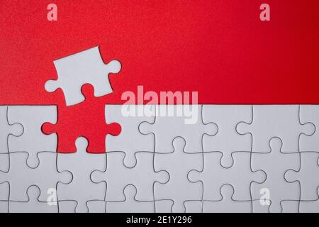 pièces de puzzle blanc non fini sur fond rouge pour la finition objectif