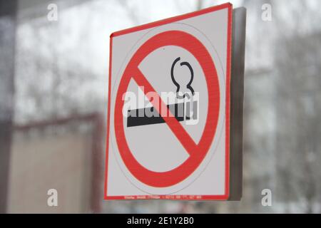 Panneau de non-fumeurs sur porte en verre, concept de soins de santé, renoncement au tabac. Fumer de la cigarette dans un cercle rouge barré. Photo de stock avec espace vide Banque D'Images