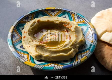 Houmous savoureux sur une assiette colorée. Vue de dessus photo de la cuisine traditionnelle d'Israël. Concept de régime équilibré. Houmous israéliens classique. Banque D'Images